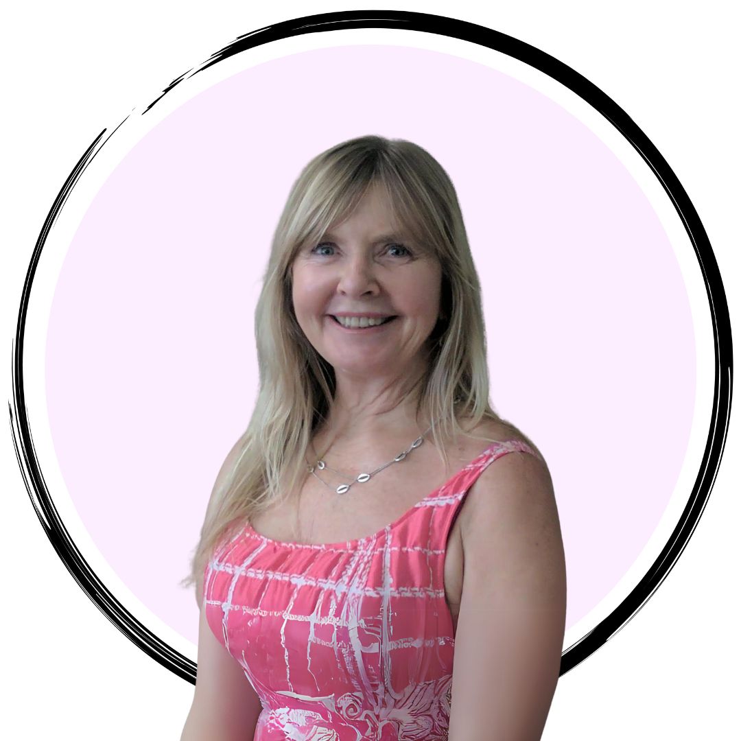 A smiling woman with long blonde hair wearing a pink patterned sleeveless top. She is standing in front of a white circle with a light pink background inside it, bordered by a black ring.